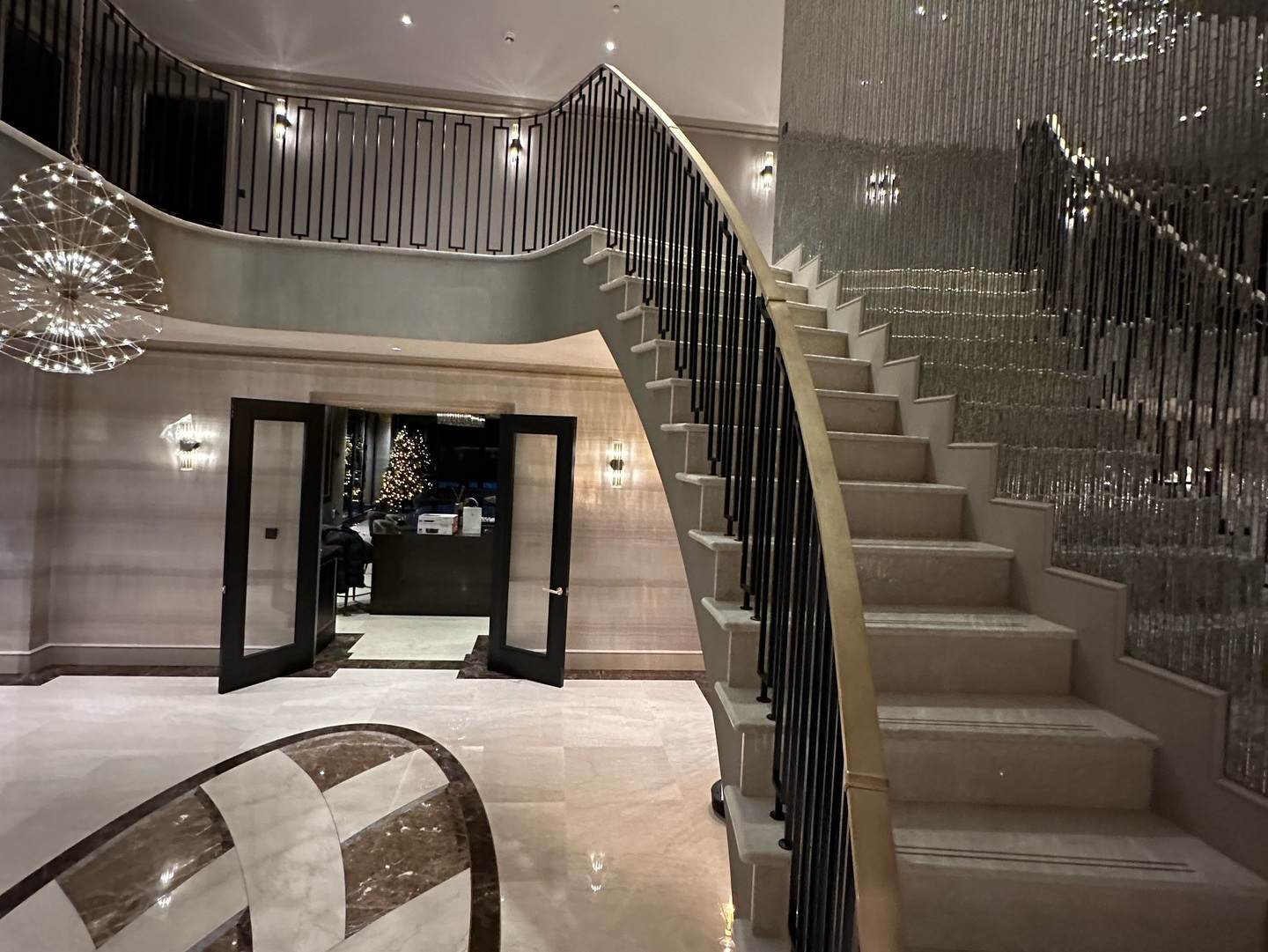 Interior of luxury property with curved staircase and chandelier