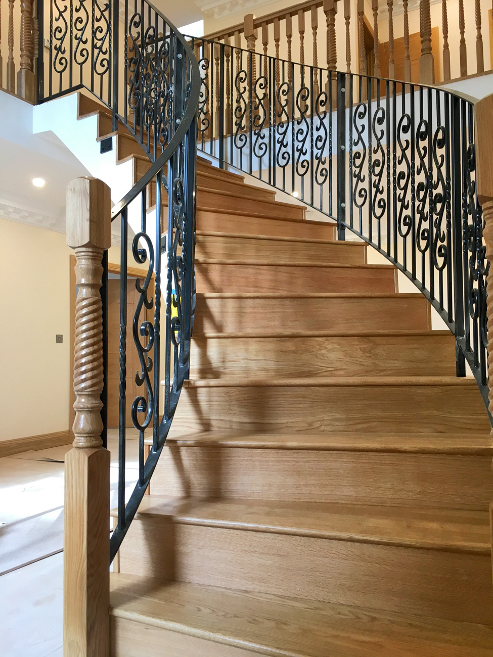 Custom home curved stairs with timber flooring and bespoke balustrade