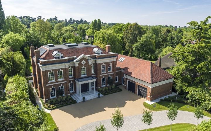 Aerial view of luxury UK home nestled in green woodland Kings Lodge Oxshott