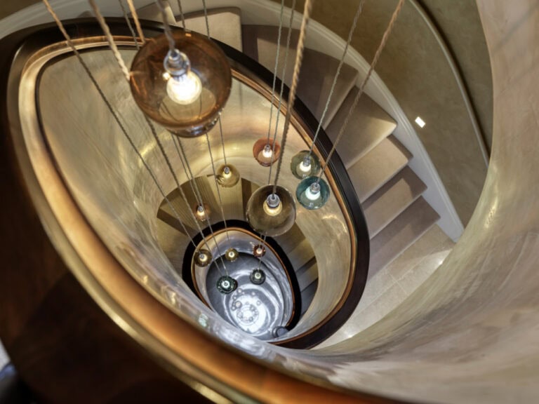 Birds eye view of luxury chandelier through curved helical staircases with carpet treads Woodside Place Chelsfield