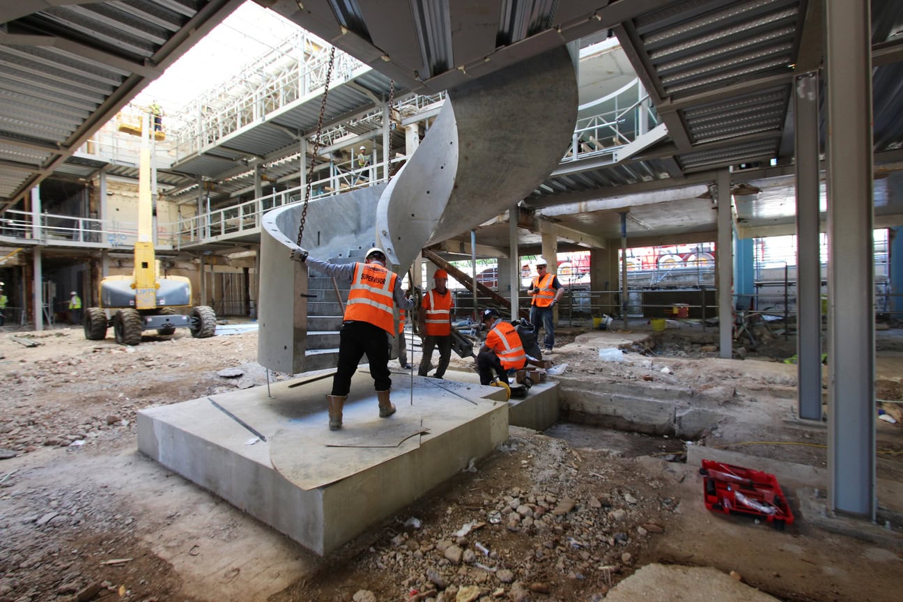 Construction works guide concrete spiral helical staircase into postion Denham Film studios Buckinghamshire