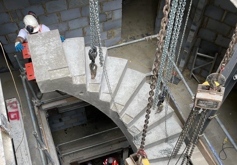 Curved helical concrete staircase lowered into position with chains Lockmead Road Tottenham