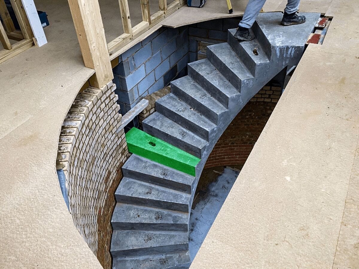 Curved precast concrete staircase with attached corbel in green to show fixing point into supporting wall