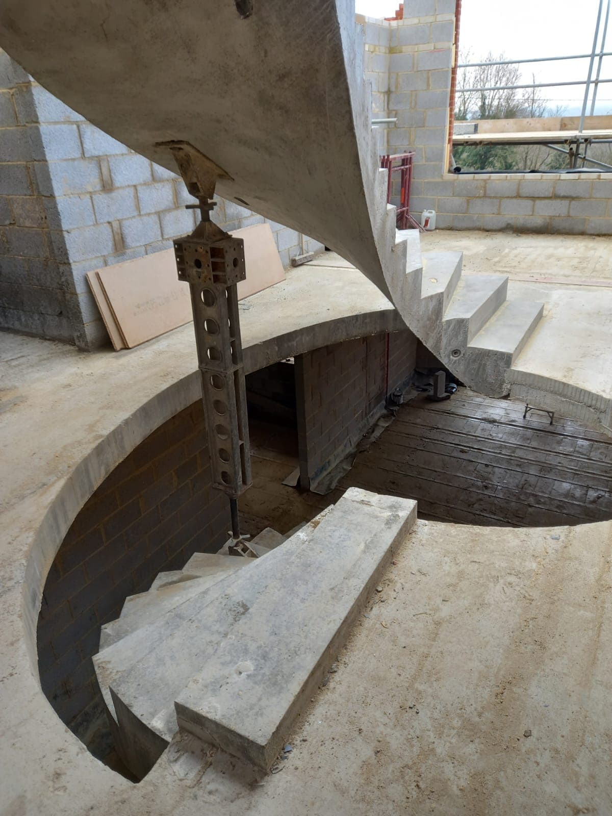 Detail close up of two precast concrete helical staircases fixed to bespoke concrete landing
