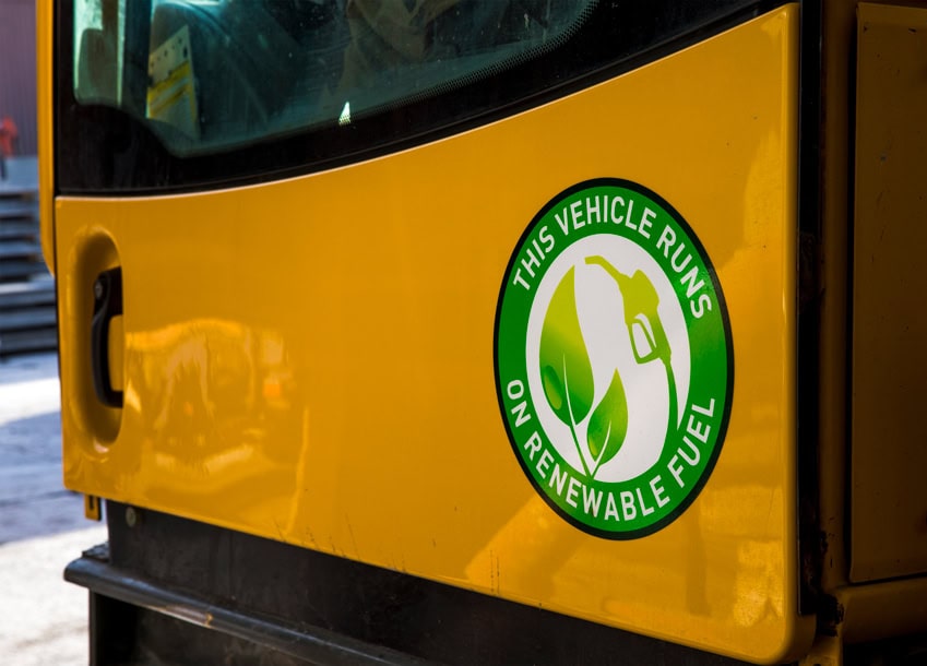 Manufacturing vehicle with sustainability sticker showing renewable fuel usage