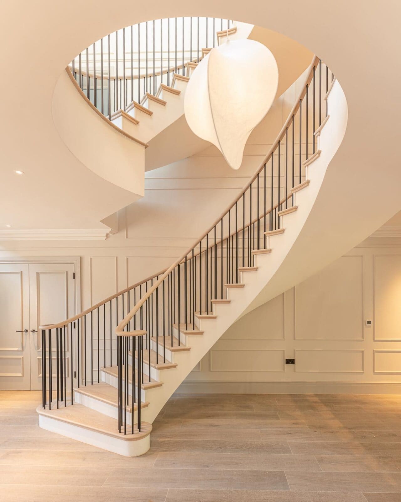 Side profile of white luxury curved helical staircase in property