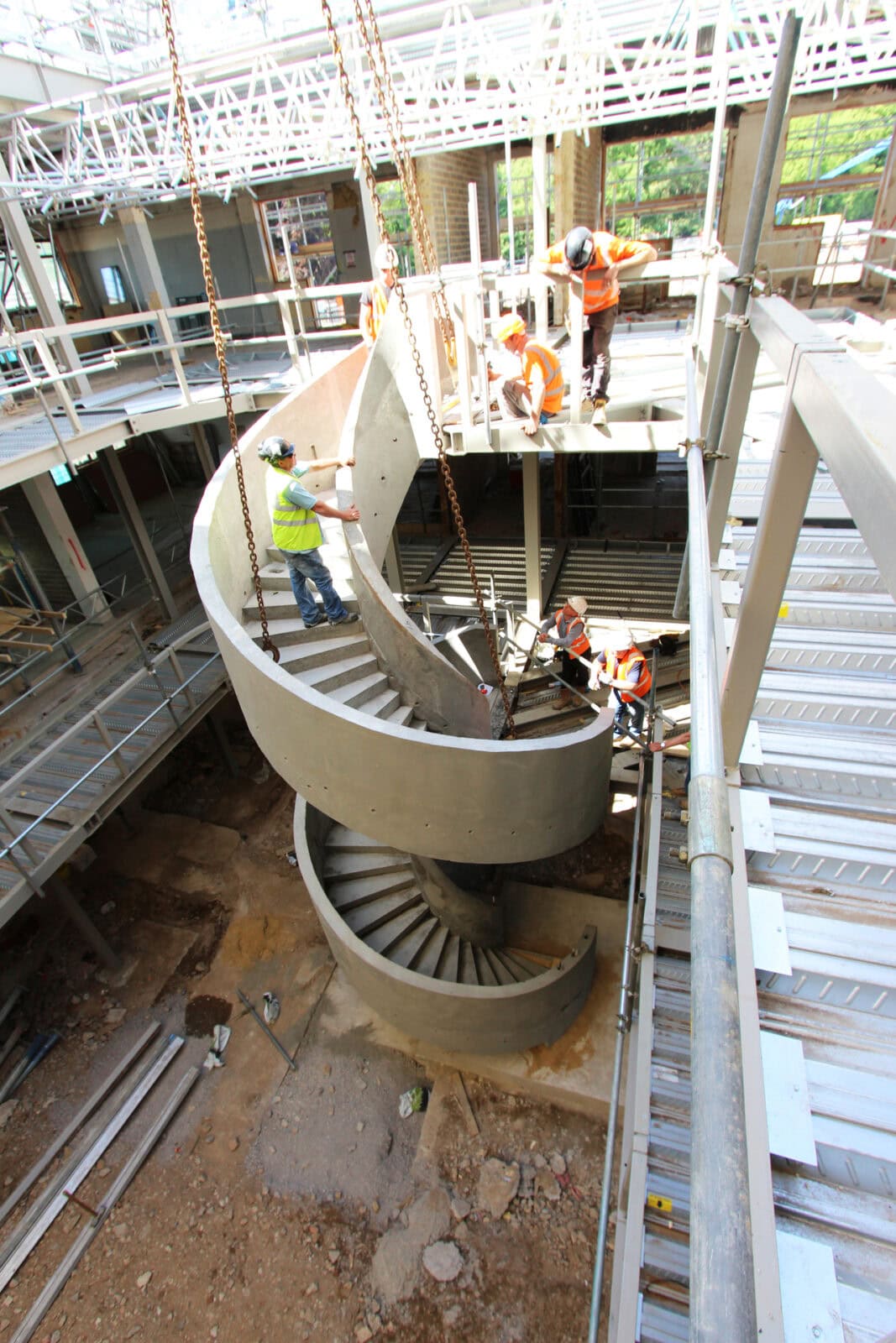 Twin large helical staircase with attached concrete handrails installation Denham Film Studios Buckinghamshire