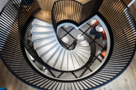 White helical curved staircase with black metal handrail